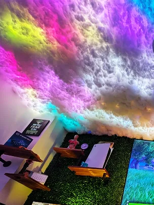 An immersive custom-built cloud ceiling with vibrant purple and blue LED lighting.