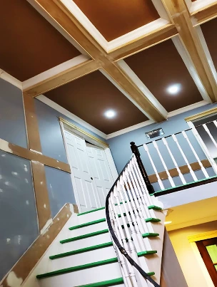 A custom coffered ceiling in a grand two-story foyer.