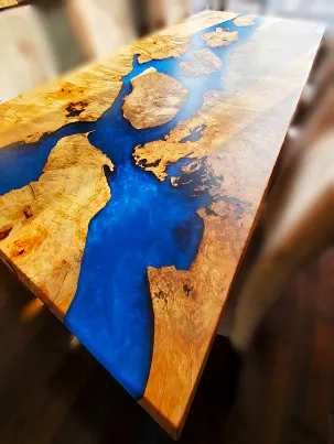 An epoxy river dining table made from maple burl