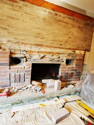 Close-up of structural brick and mortar repair work on a fireplace.