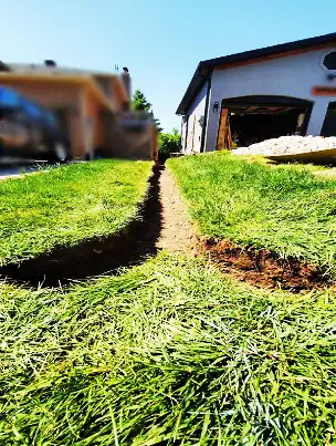 A properly graded trench being prepared for a French drain installation.