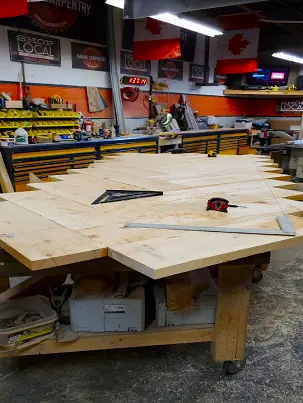 A craftsman milling and joining boards in a workshop.